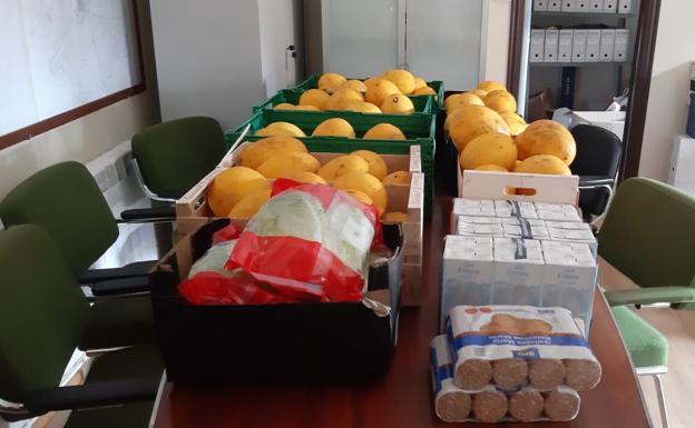 Melones, lechugas, leche y galletas preparados para su reparto.