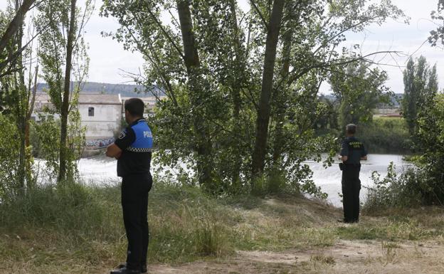 Agentes vigilan desde la orilla.