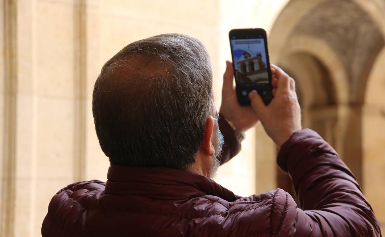 Un visitante fotografía una de las torres de San Isidoro. 