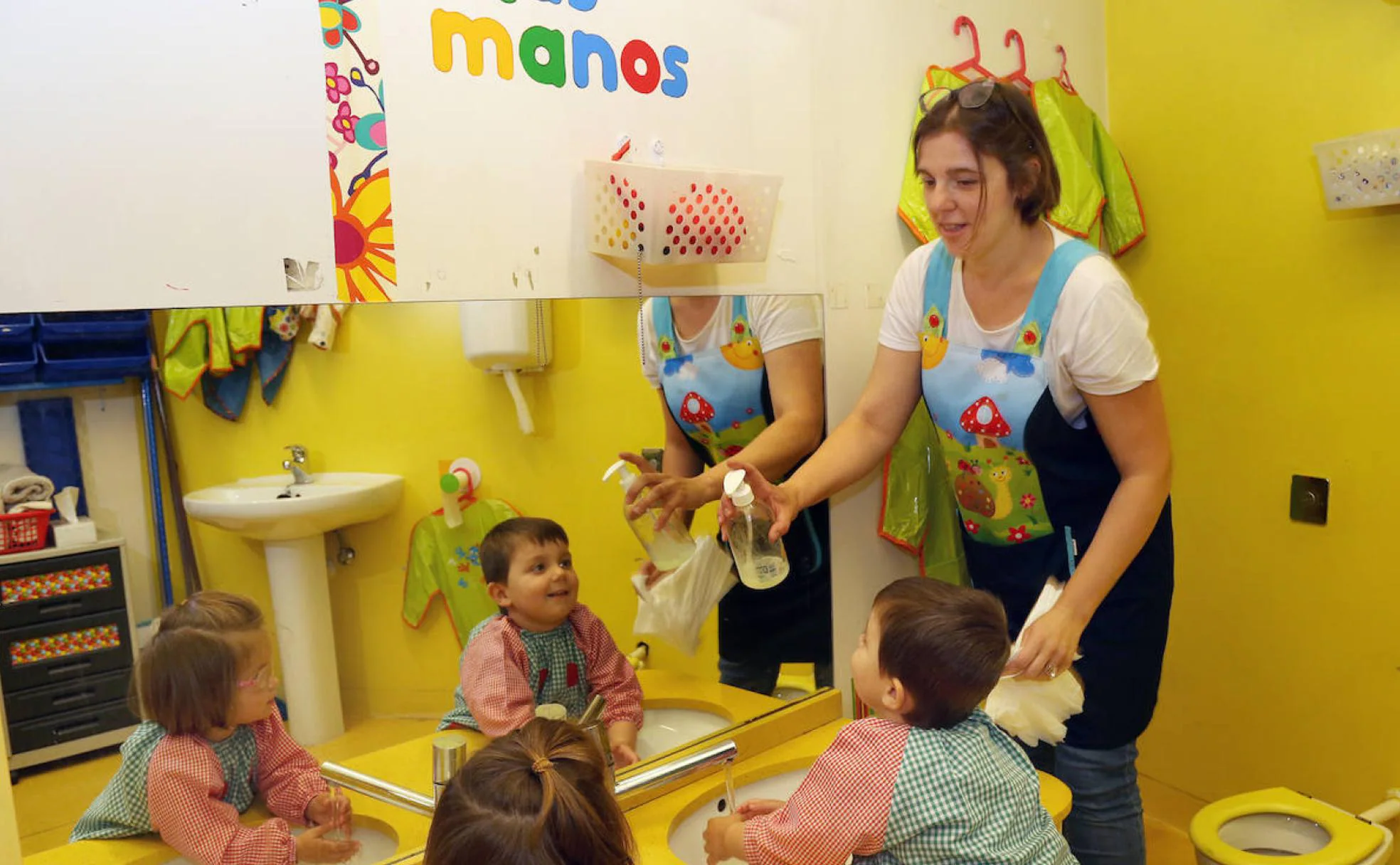 Yolanda Rodríguez lava las manos a dos niños, ayer en El Gusanito.