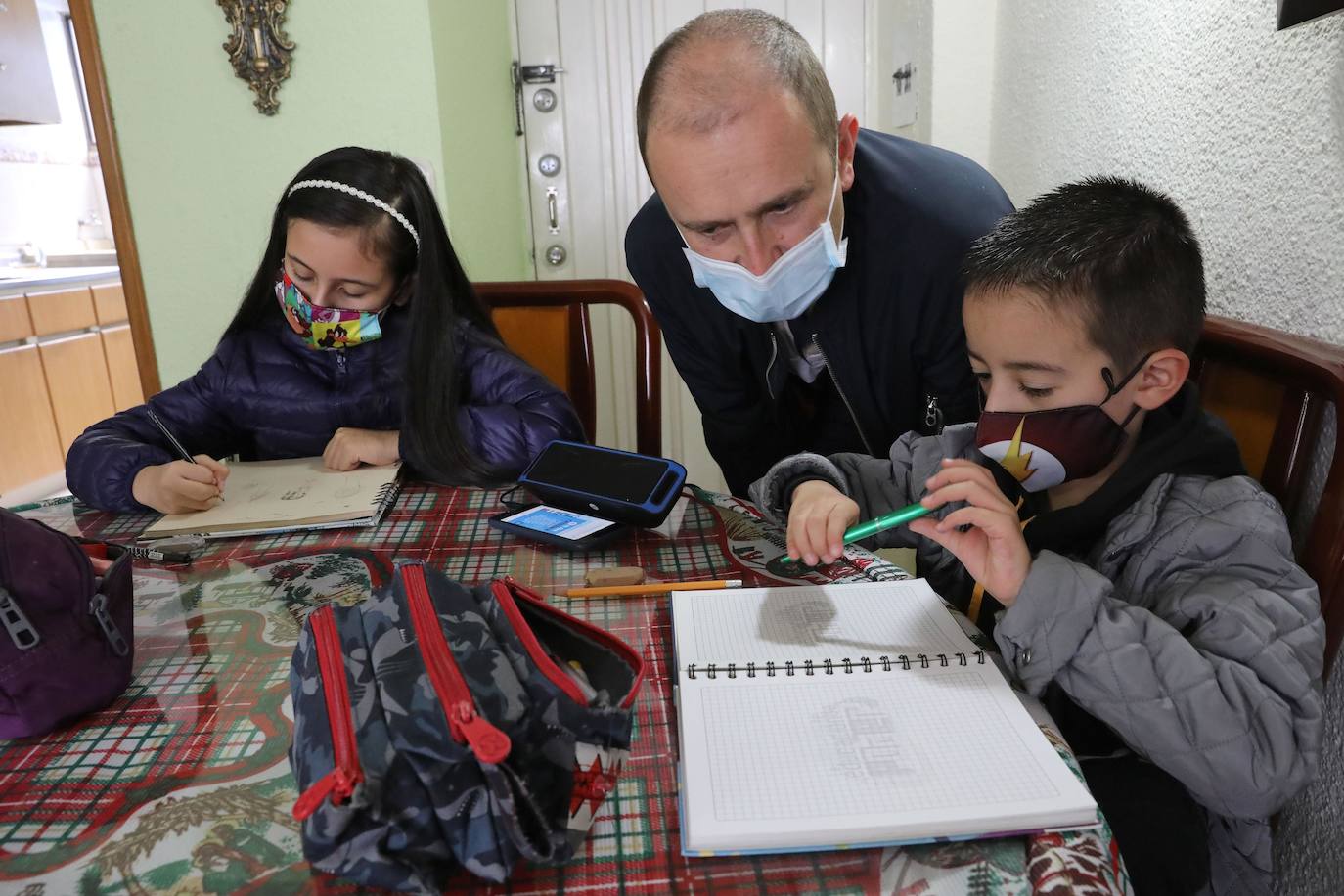 Dos niños estudiando en su casa durante la pandemia.