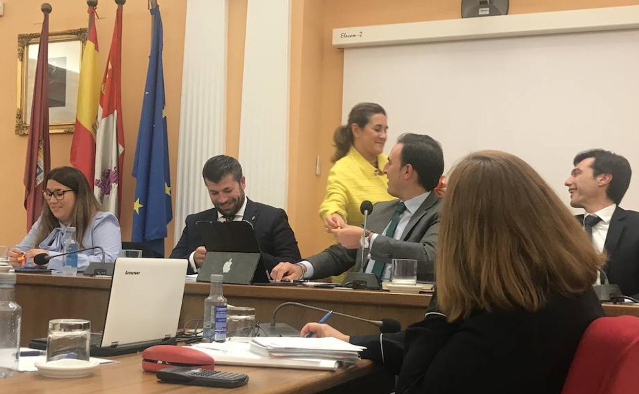 El alcalde de Medina, Guzmán Gómez, saluda a Olga Mohíno (de pie) en un pleno.