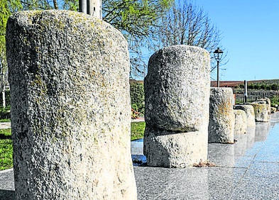 Imagen secundaria 1 - Arriba, mirador con carteles explicativos sobre la calzada romana; hilera de piedras, algunas de ellas parte de miliarios romanos y piedra gótica embutida en un arco de la iglesia.