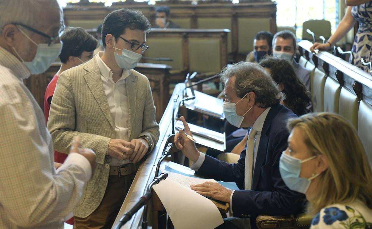 Pedro Herrero escucha a José Antonio de Santiago-Juárez, en los intantes previos al Pleno, en la bancada popular, con Pilar del Olmo en primer término. 