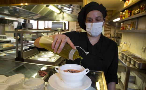 Imagen principal - Arriba, la jefe chef de La Criolla da el último toque a su salmorejo tradicional cordobés., que aparece abajo a la izquierda. A la derecha, la capa que Paco Martínez recibió cuando fue nombrado embajador del Aceite Virgen en Baena. 