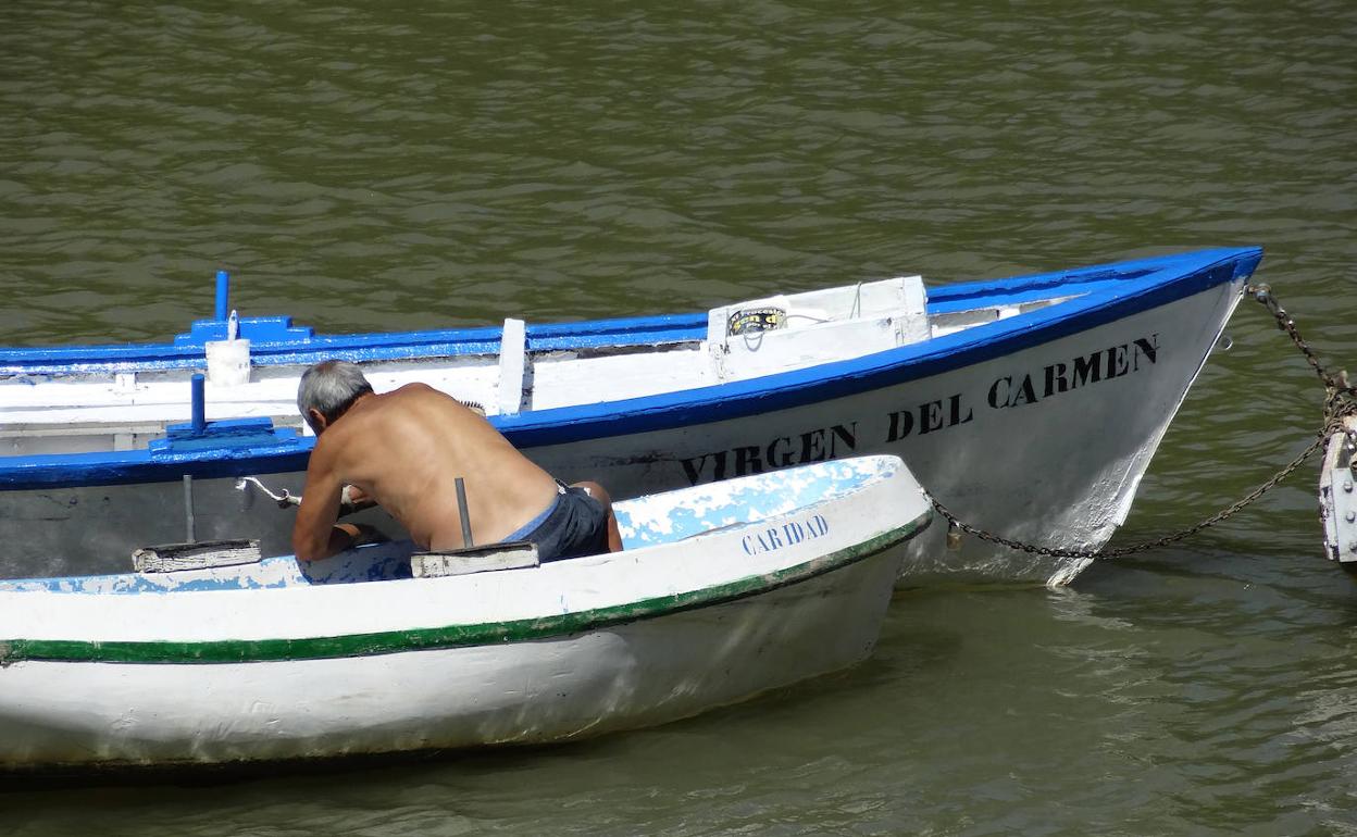 Un voluntario de Los Amigos del Pisuerga da los últimos retoques a la patera de la Virgen del Carmen.
