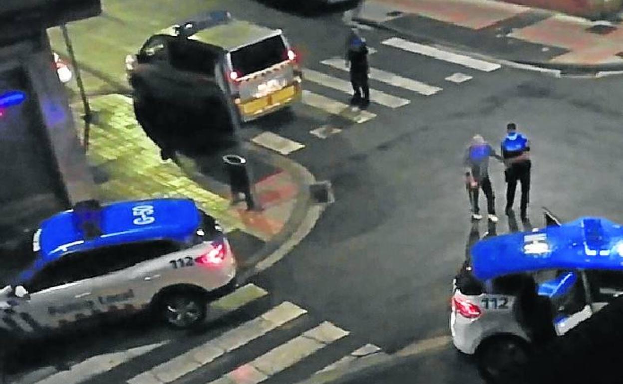 Un policía local acompaña al conductor ebrio hacia un coche patrulla..