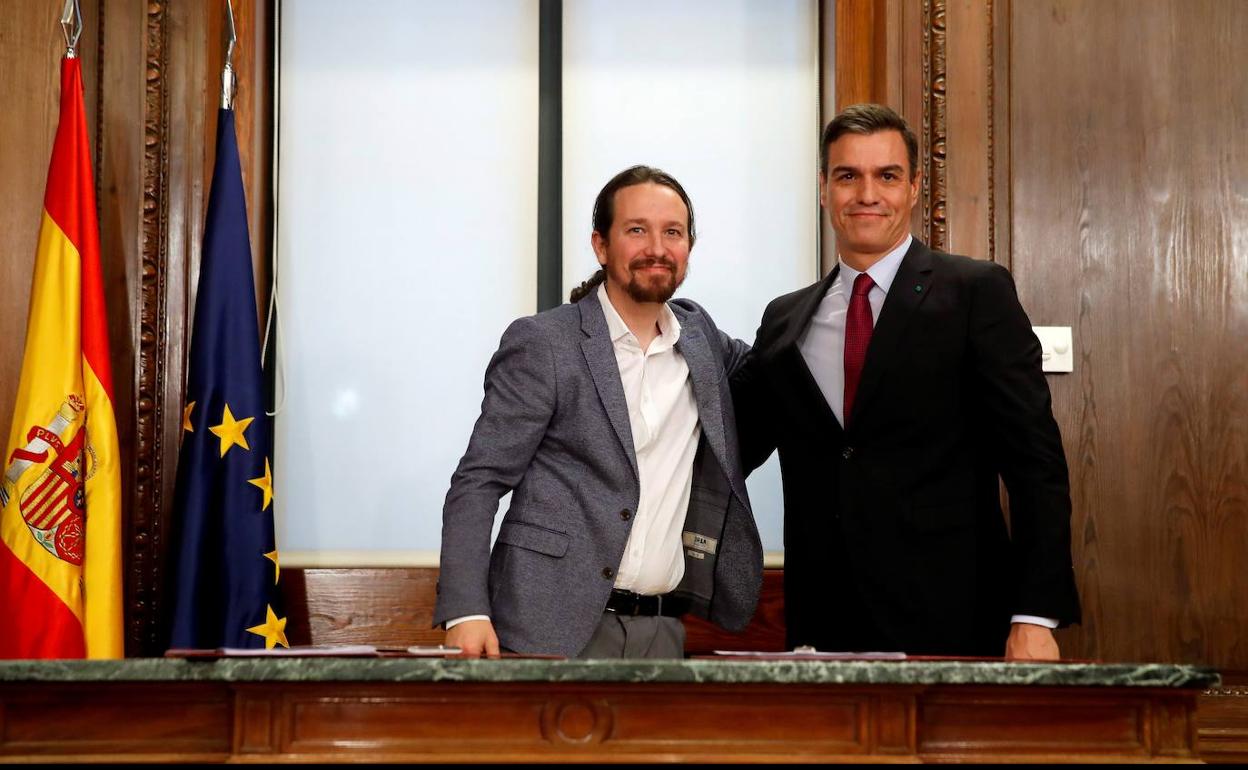 Sánchez e Iglesias tras la firma el pasado 30 de diciembre en el Congreso del acuerdo para gobernar en coalición.