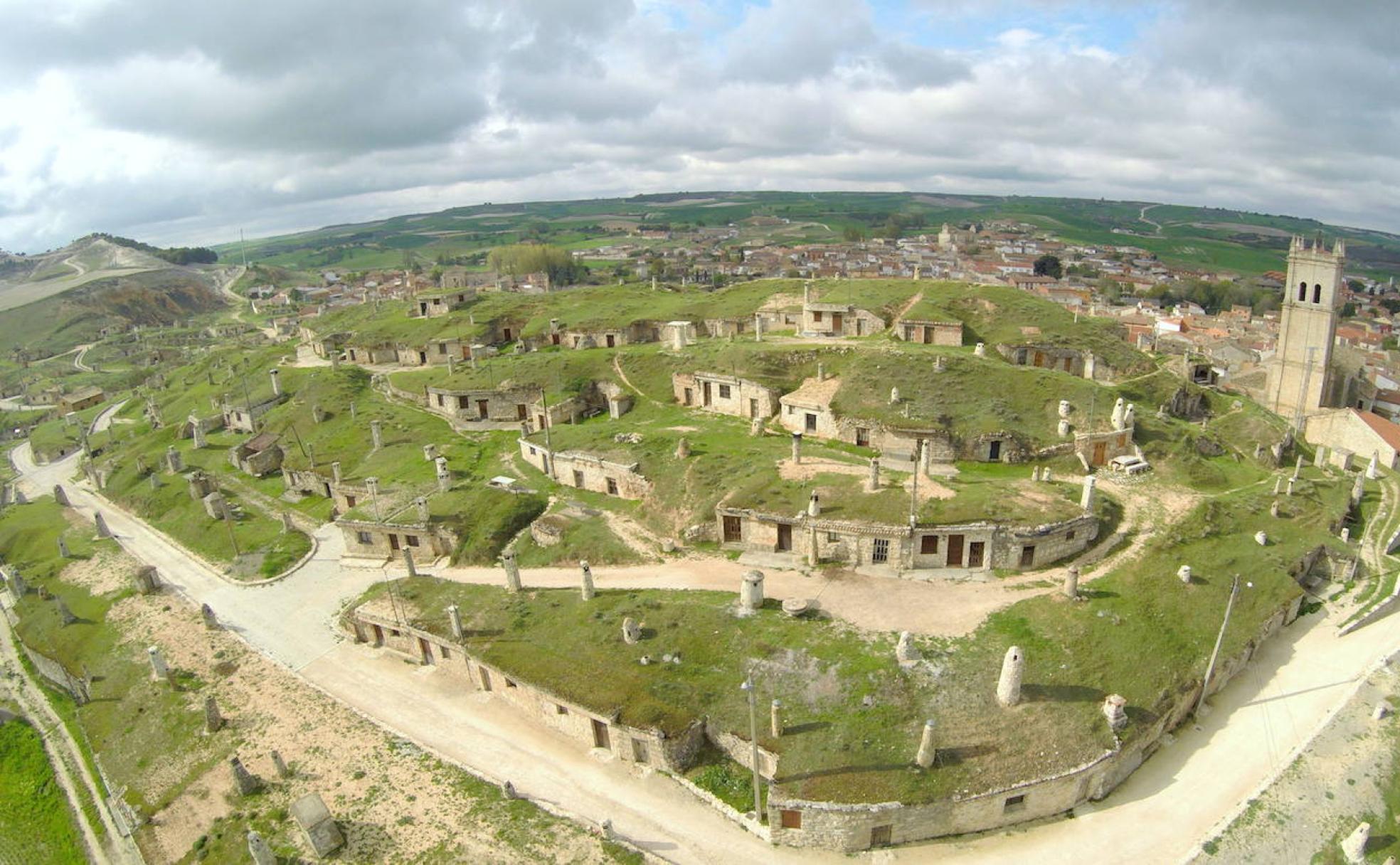 Vista aérea del barrio de las bodegas en el cerro que oculta desde esta perspectiva gran parte del casco urbano de Baltanás. A la derecha, la torre de la iglesia parroquial de San Millán. 