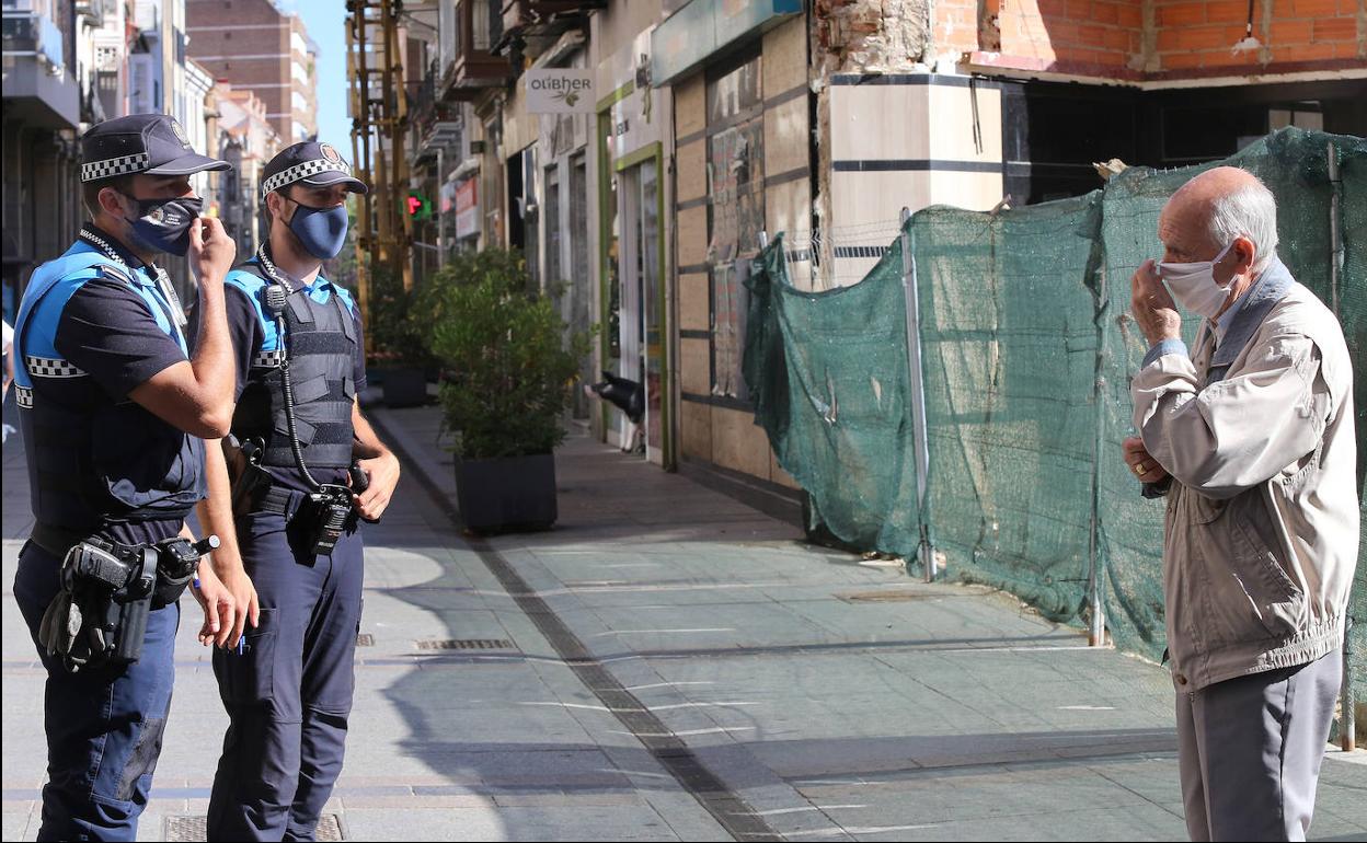 El oficial Herrero explica a un ciudadano en la Calle Mayor que la protección también tiene que cubrir la nariz.