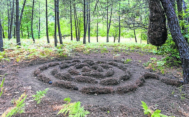 Imagen principal - Arriba, una de las obras de 'land art' en El Collao; portada de la iglesia luce un escudo con conchas de peregrino y estela funeraria del siglo XIV que fue encontrada en la iglesia en 2013. .