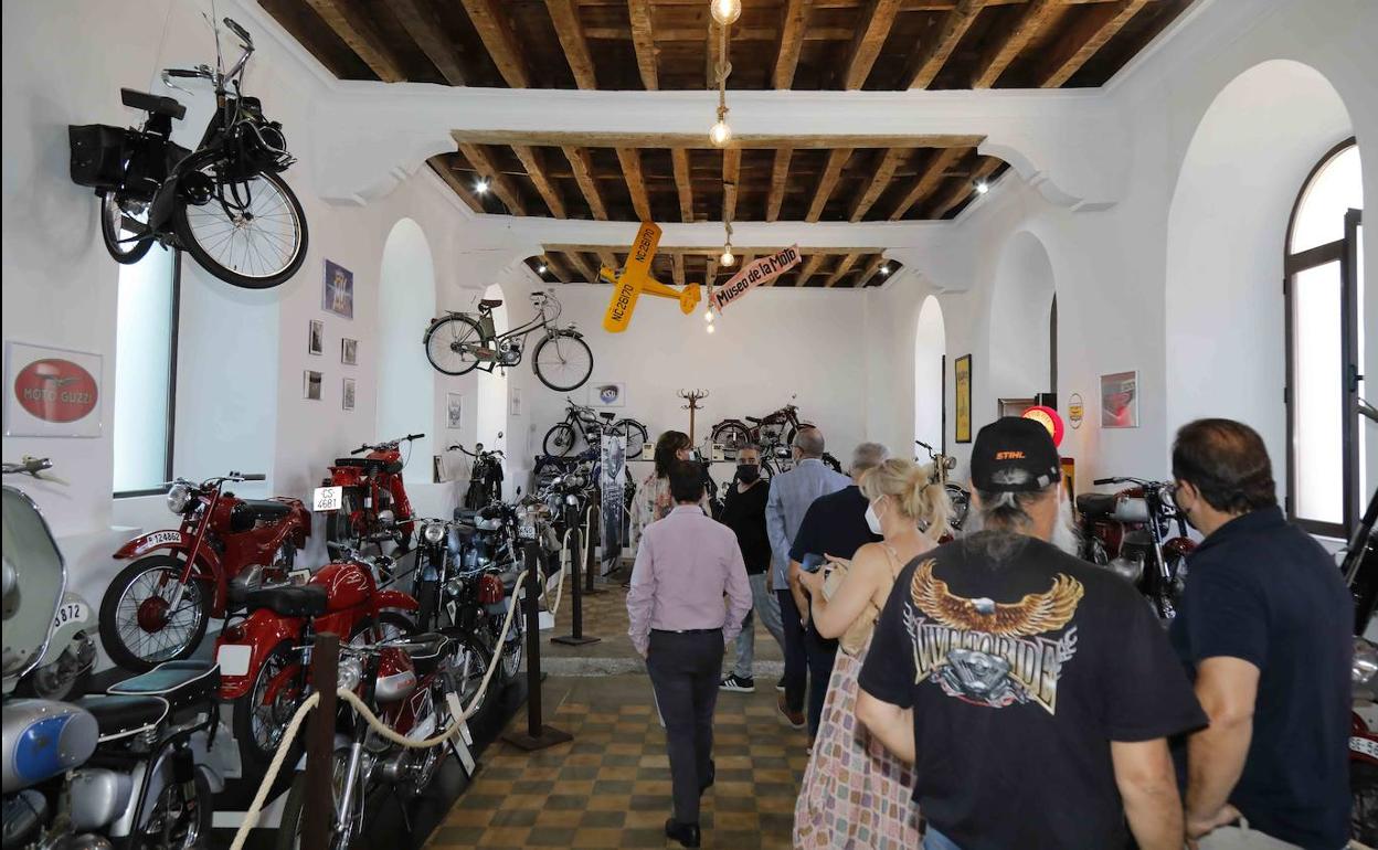 Varios de los asistentes a la inauguración contemplan la colección de motos del museo. 