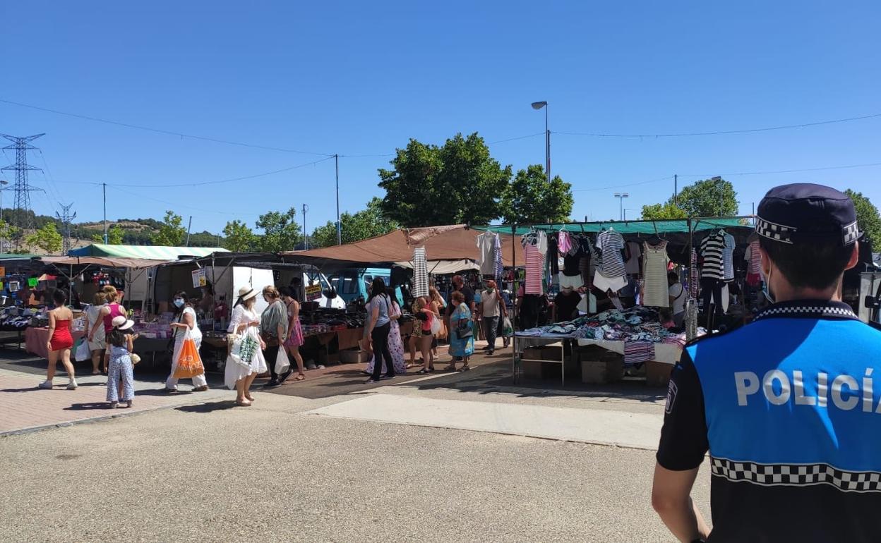 Un policía vigila el mercadillo.