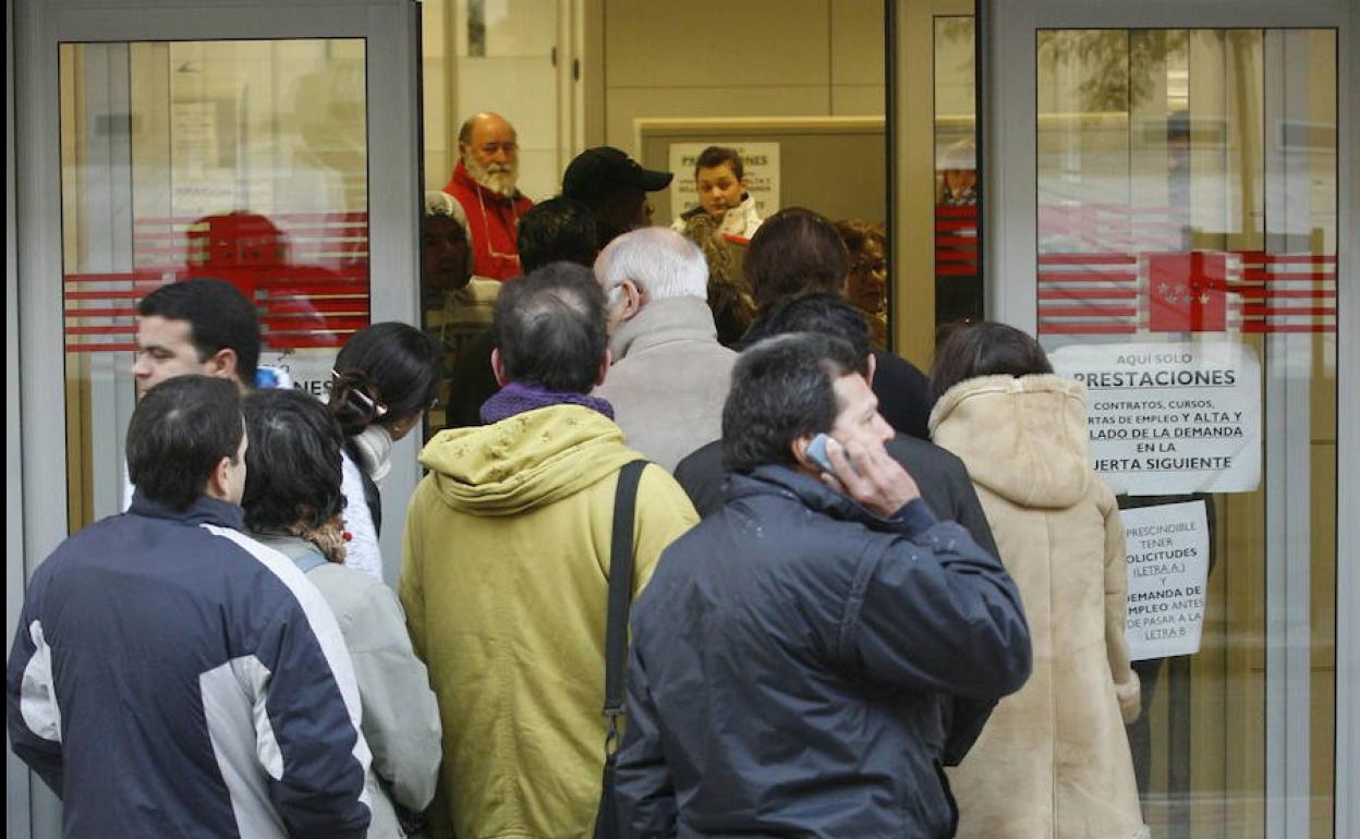 Un grupo de personas hacen hoy cola en la entrada de una oficina de empleo.