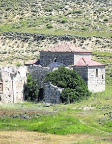 Imagen secundaria 2 - Arriba, barrio de las bodegas de la localidad; vista panorámica del característico edificio de las escuelas y ermita de la Virgen de los Remedios, en las cercanías del pueblo. 