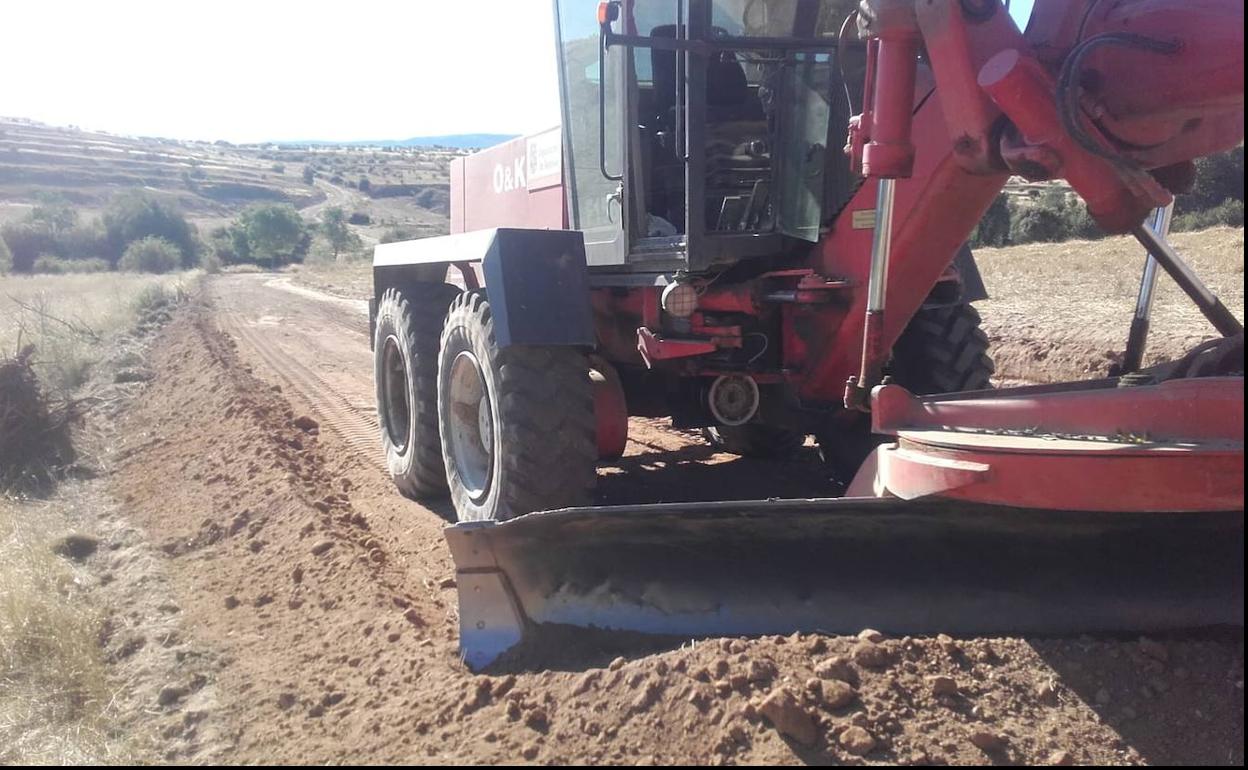 Una motoniveladora trabaja en un camino. 