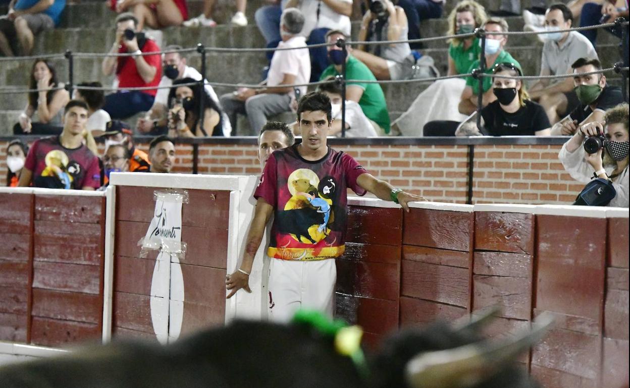 Uno de los recortadores del concurso de este viernes en El Espìnar mira fijamente al novillo desde el burladero. 