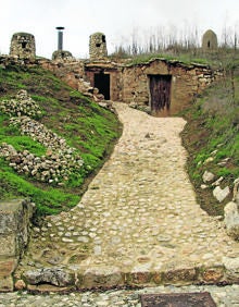 Imagen secundaria 2 - En la parrte superio, bajada a una bodega mucenteña; prensa vertical en el Museo del Vino y camino de piedra entre varias bodegas.