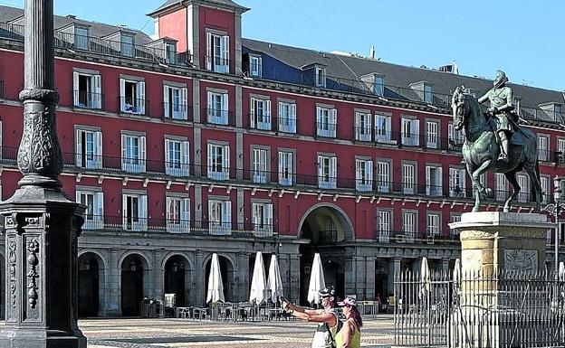 Imagen principal - La Plaza Mayo (arriba), la Puerta del Sol (centro) o el Museo de Prado, donde toca un músico callejero (abajo), son los centros turísticos de obligada visita en Madrid.