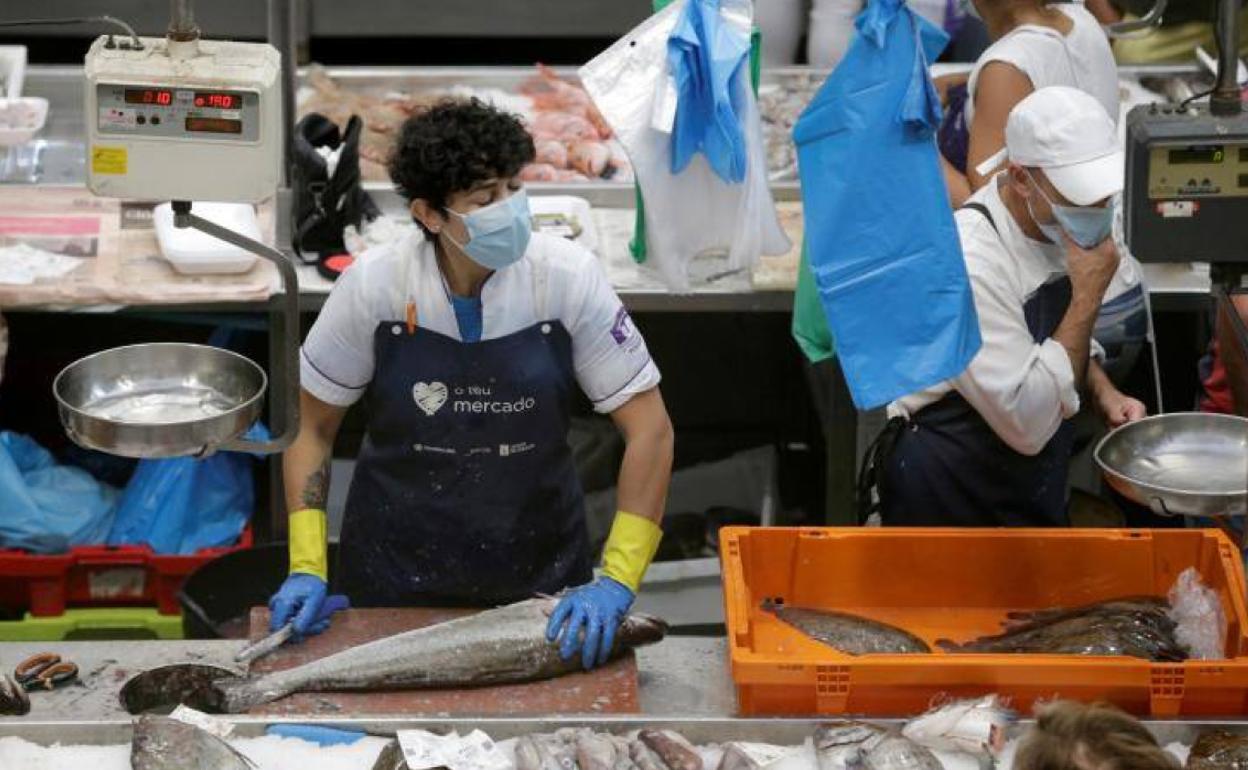 Pescaderos con mascarilla en un mercado de Pontevedra.