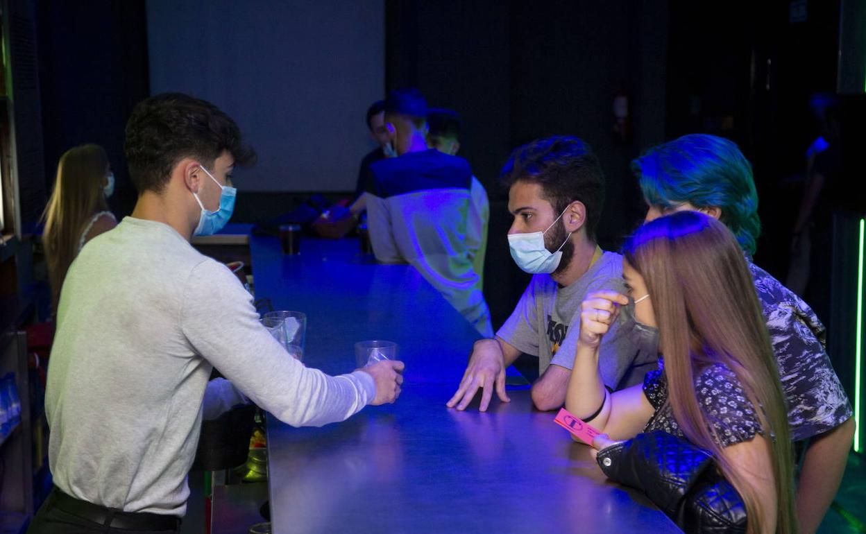 Jóvenes con mascarilla en un local de ocio nocturno de Valladolid. 