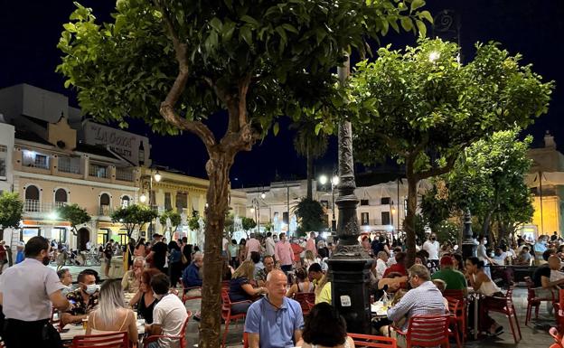 Imagen principal - Ambiente en la plaza del Cabildo (arriba), playa de Sanlúcar de Barrameda (centro) y basílica de la Caridad.