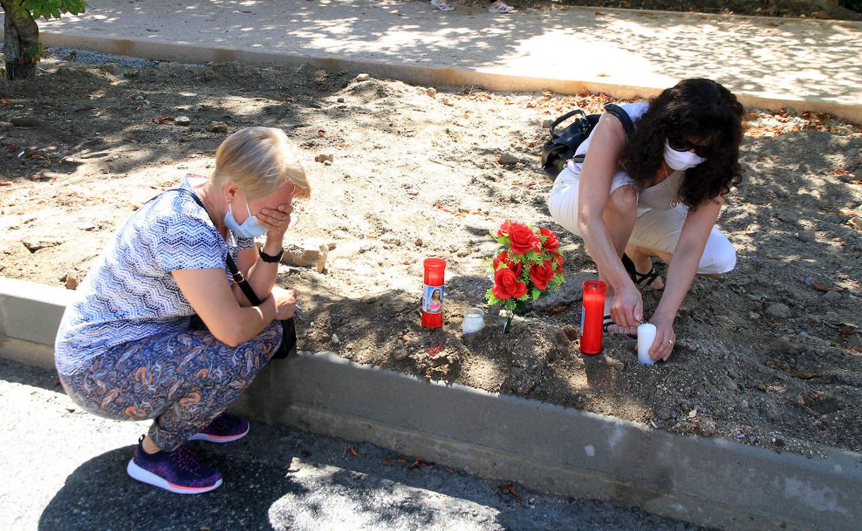 Amigas de la fallecida colocan unas rosas y unas velas en el lugar donde murió, en la carretera de Madrid de La Granja. 