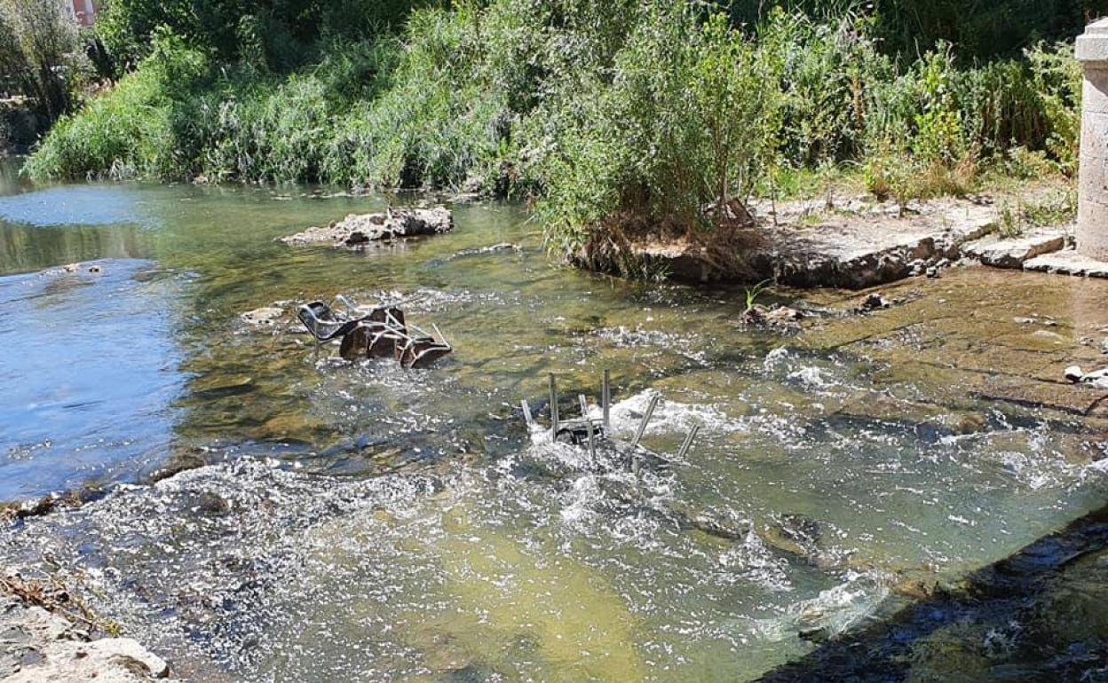 Sillas de un establecimiento hostelero de la plaza de España que han aparecido tiradas en el Duratón a su paso por Peñafiel.