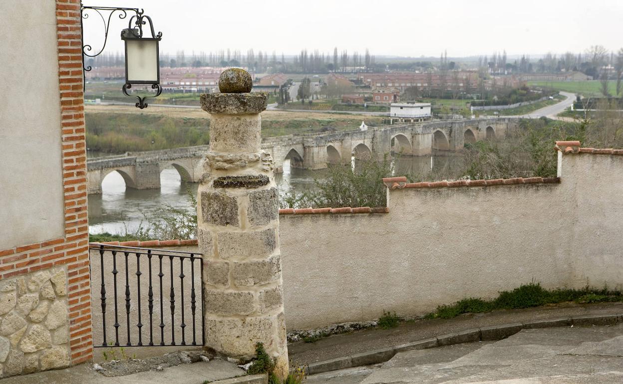 Rollo de Justicia de Simancas, en primer término, con el río Pisuerga y el puente que lo cruza al fondo.