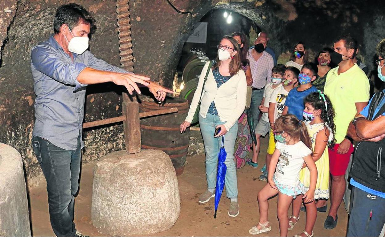Un guía explica a un grupo reducido el método tradicional de elaboración del vino de Torquemada.