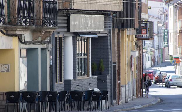 Terraza de un bar vacía y apenas se ven peatones en una calle de Cantalejo a la hora del aperitivo.