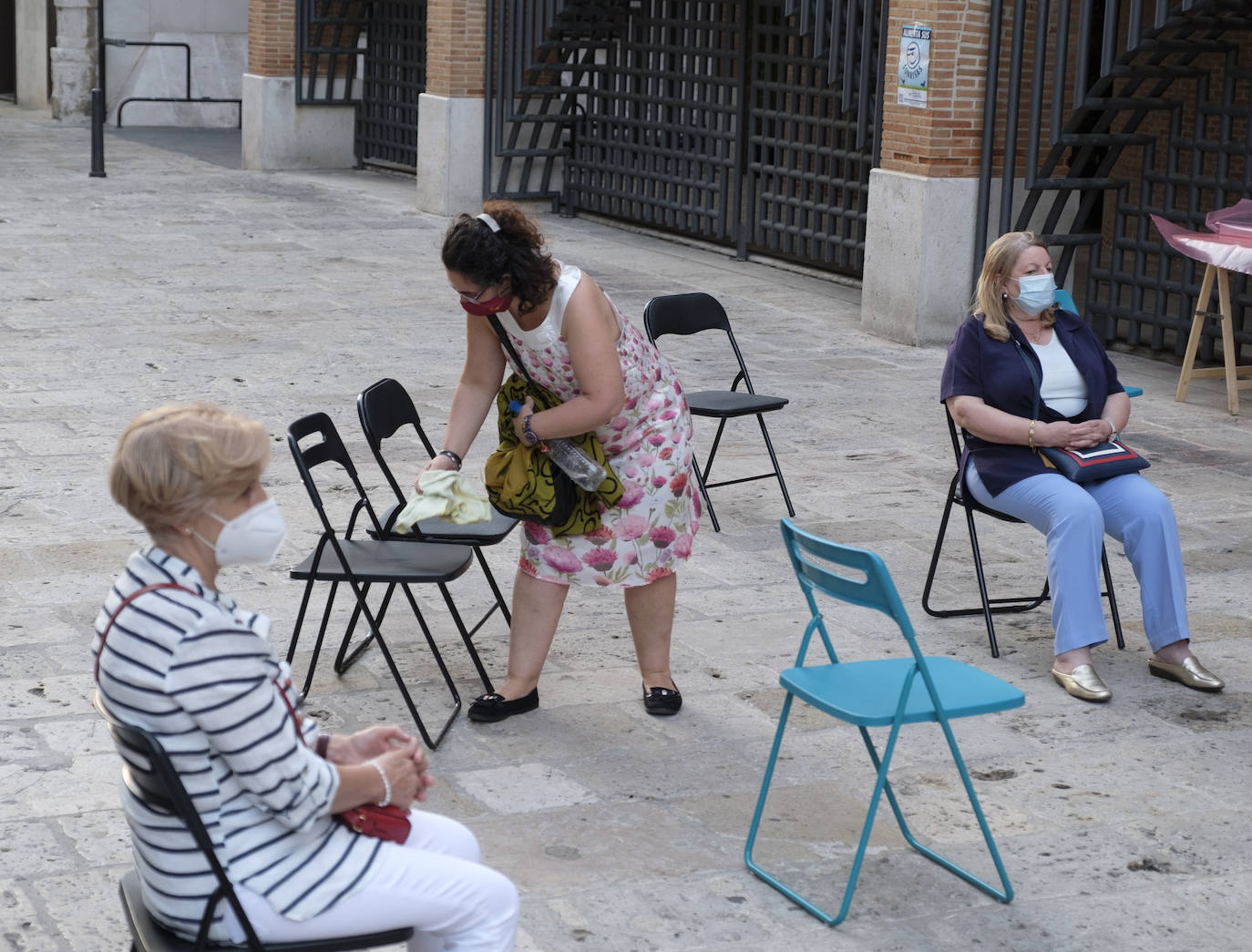 Hay sillas negras, azules y verdes, esparcidas por el empedrado suelo del acceso a la iglesia de San Lorenzo, en la calle Pedro Niño | Y allí, sentados, en la calle y con la vista en el interior del templo, un grupo de fieles sige la celebración