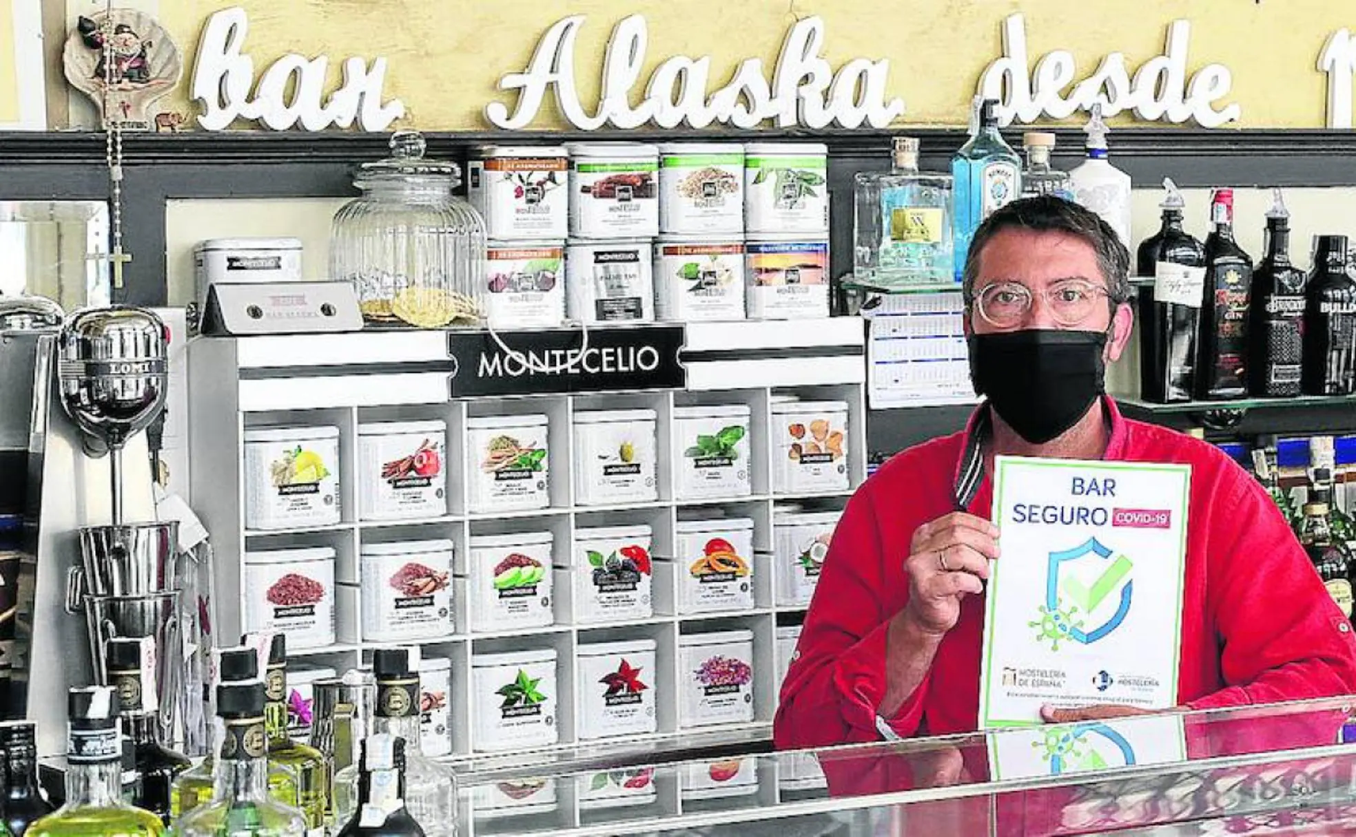 Luis Rebollo, propietario del bar Alaska, posa con el logo de bar seguro. 