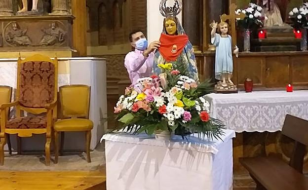 El teniente de alcalde de Alcazarén pone el pañuelo festivo a la patrona. 