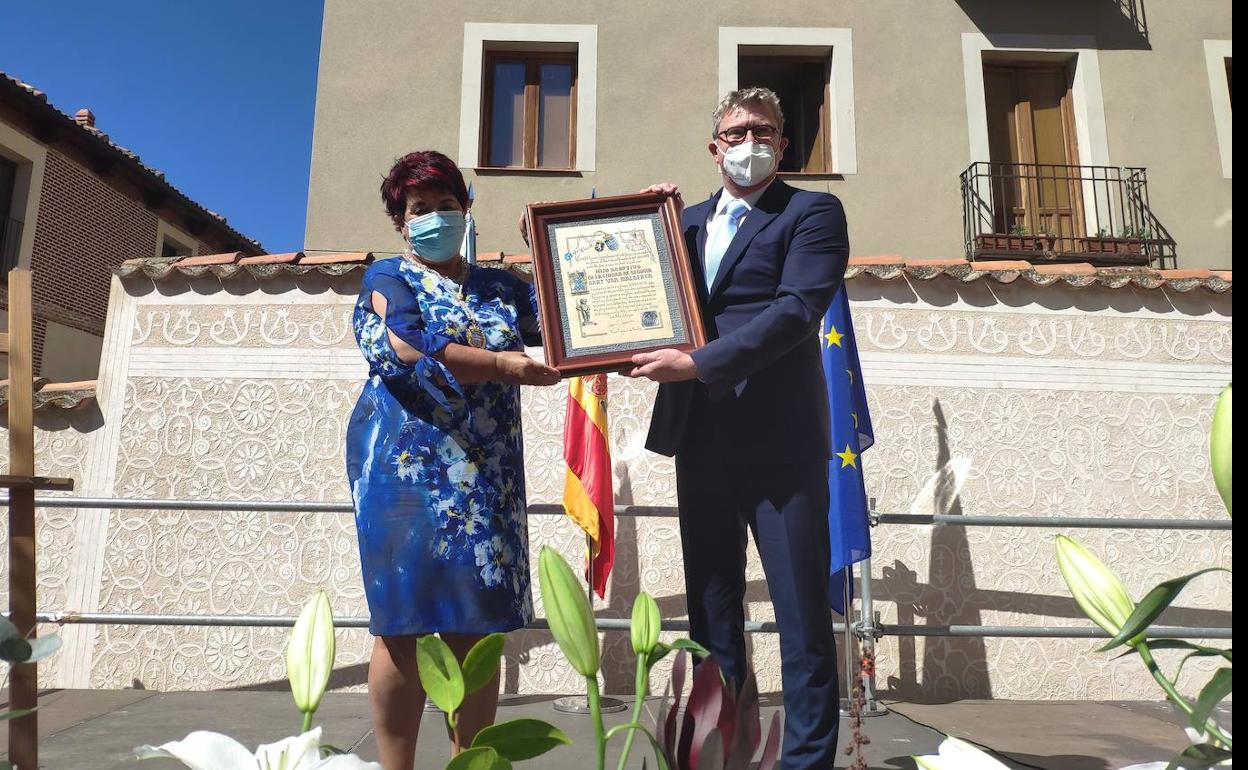 Bart Van Malderen recibe el título de manos de Clara Luquero.