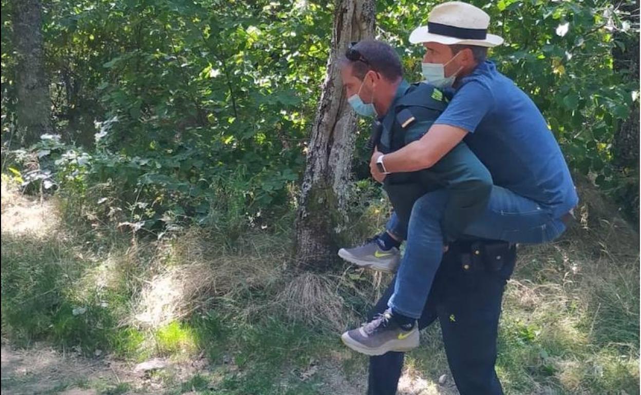 El agente porta al hombre herido en la senda de la Pedrosa.