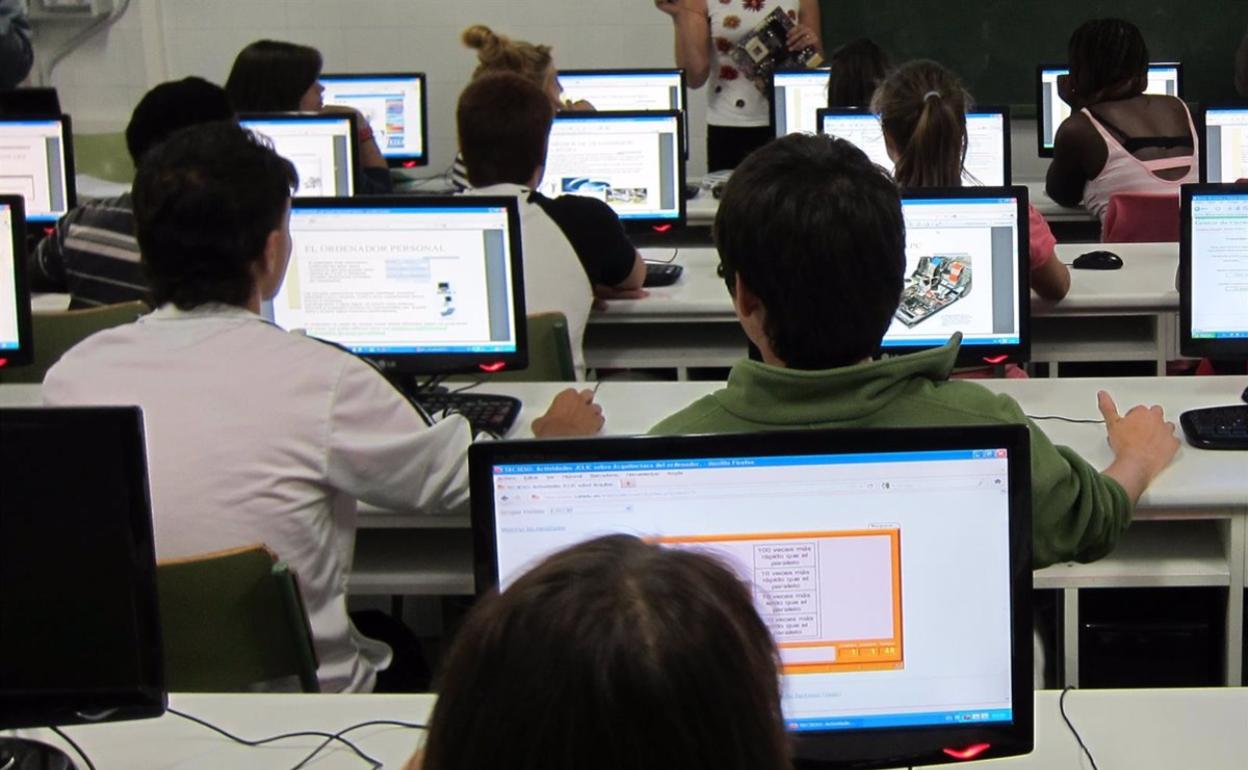 Alumnos en un aula con ordenadores.