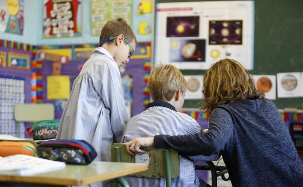 Una profesora atiende la dudas de dos alumnos en el Colegio Internacional de Valladolid. 