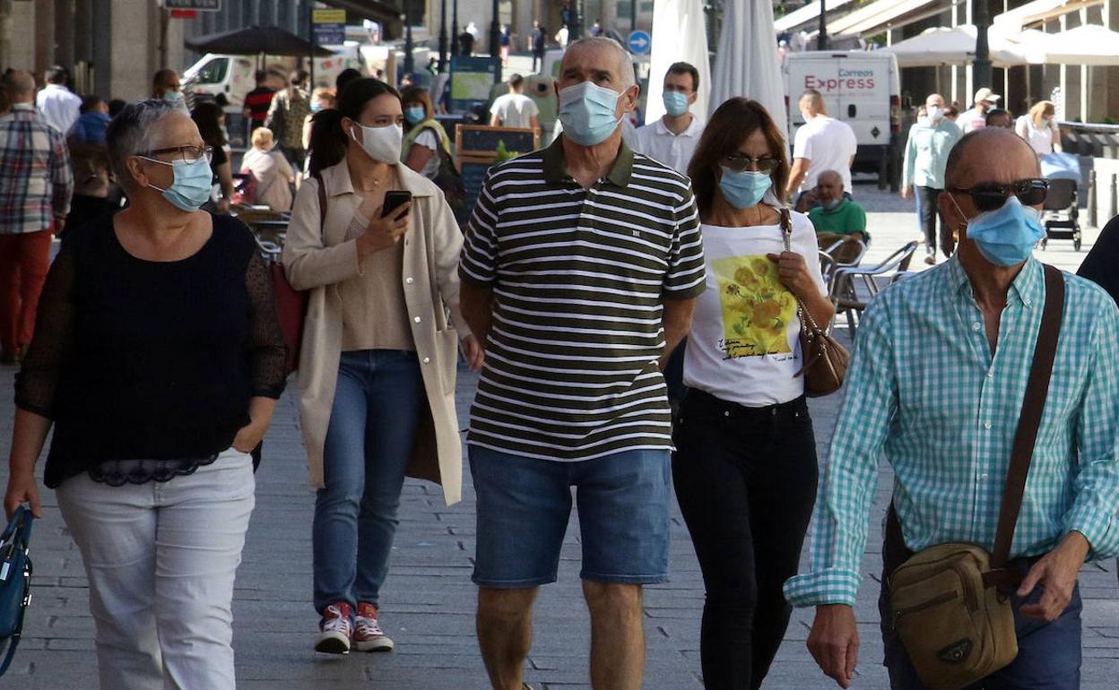 Personas con mascarilla por la calle.