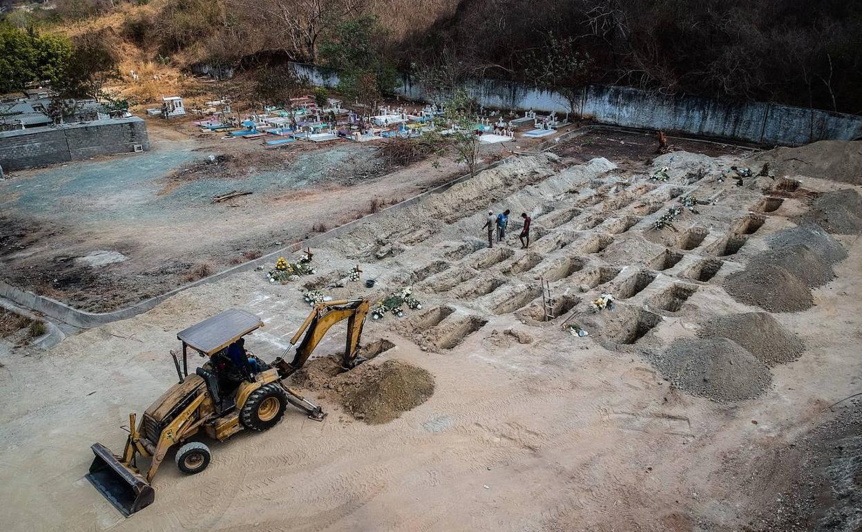 Trabajadores funerarios cavan fosas en la localidad mexicana de Acapulco, el pasado mayo, para enterrar a los muertos por coronavirus. 