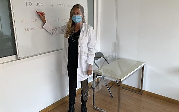 Inma Hernando, en una de las aulas, entre la pizarra y la mampara de protección. G. L.