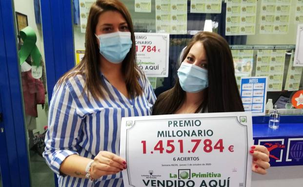 Empleadas de la administración de Vía Roma muestran el cartel con el premio, este viernes. 