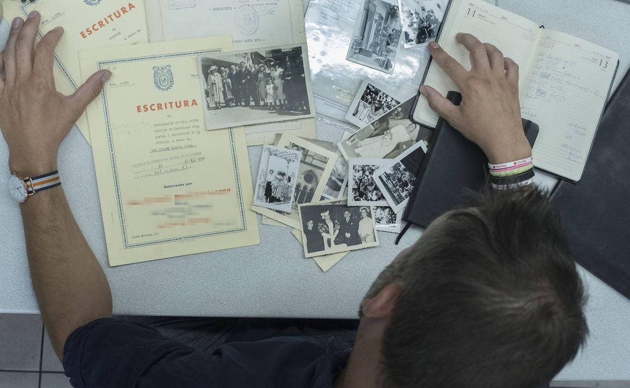 Un hombre revisa unas escrituras y documentos familiares.