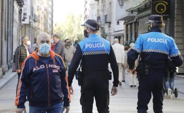 Policías y vecinos de Palencia paseando por la ciudad horas antes de que se confine. 