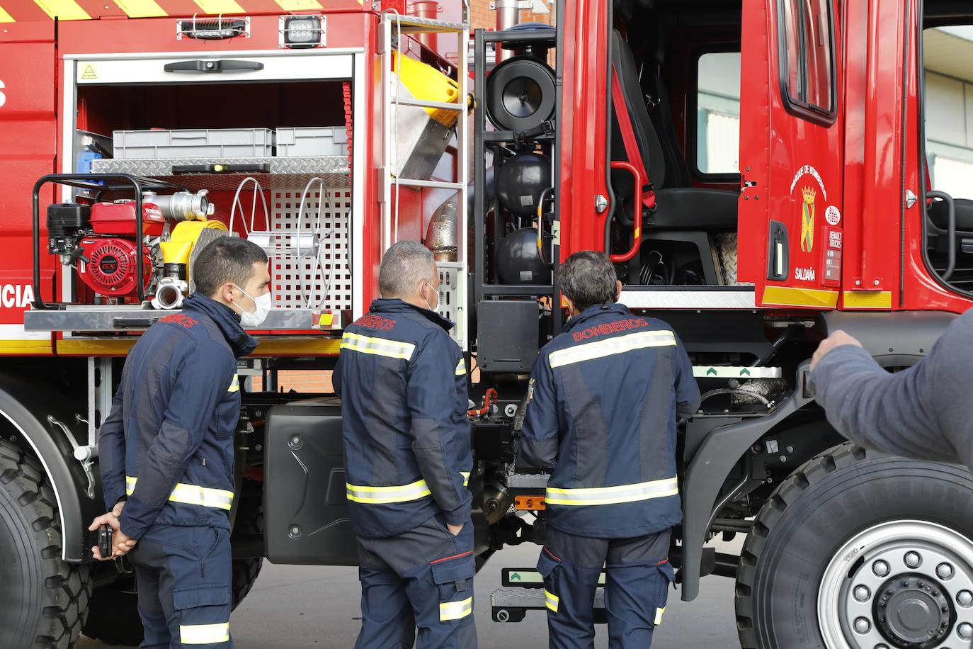 Los bomberos voluntarios de Saldaña examinan el nuevo vehículo de su equipo.