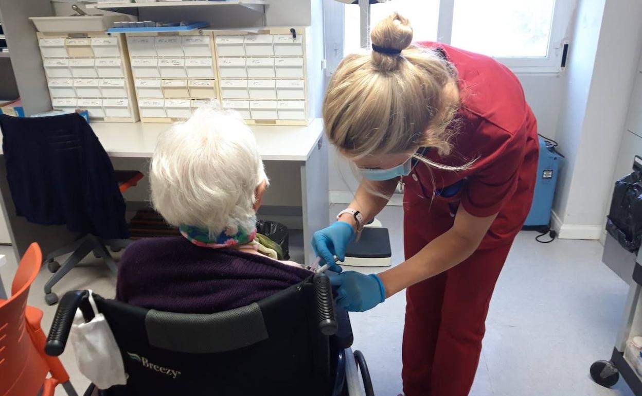 Una trabajadora de una residencia de la Diputación de Segovia vacuna a una anciana contra la gripe esta semana. 