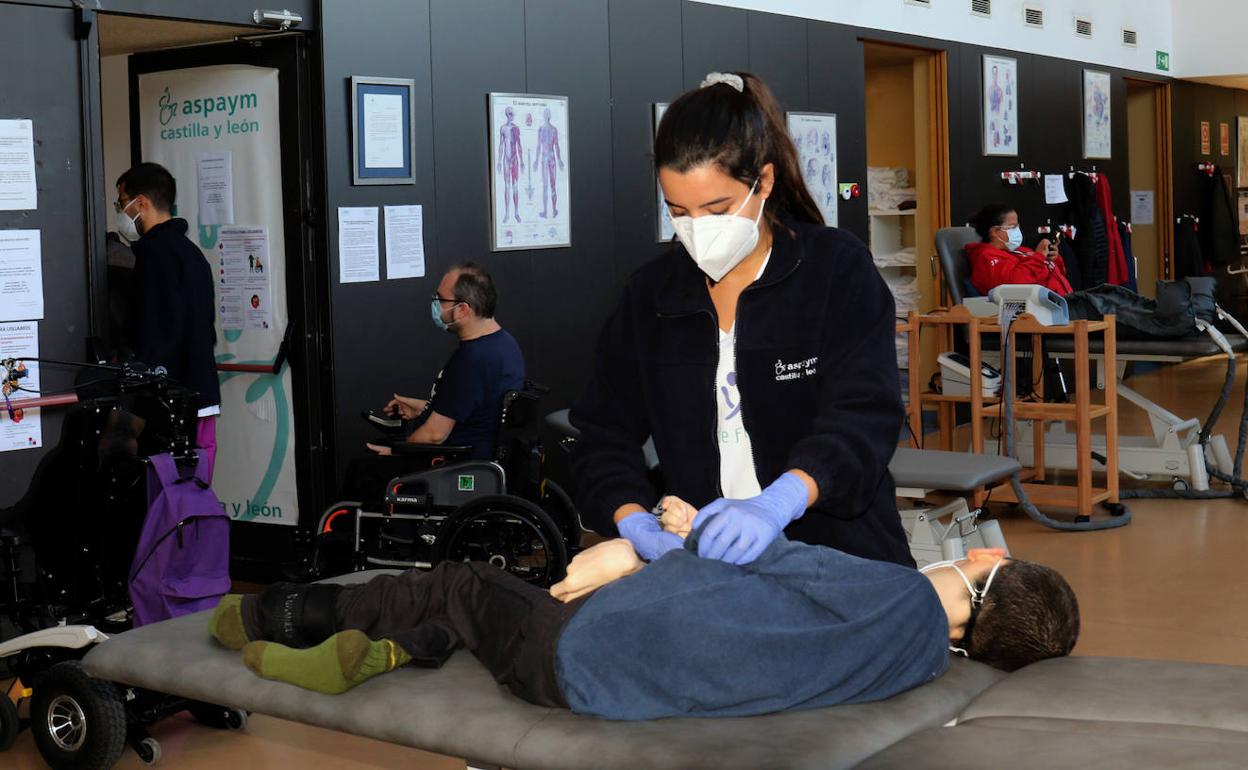 Una fisioterapeuta atiende a un usuario del Centro de Rehabilitación de Aspaym en Valladolid.. 