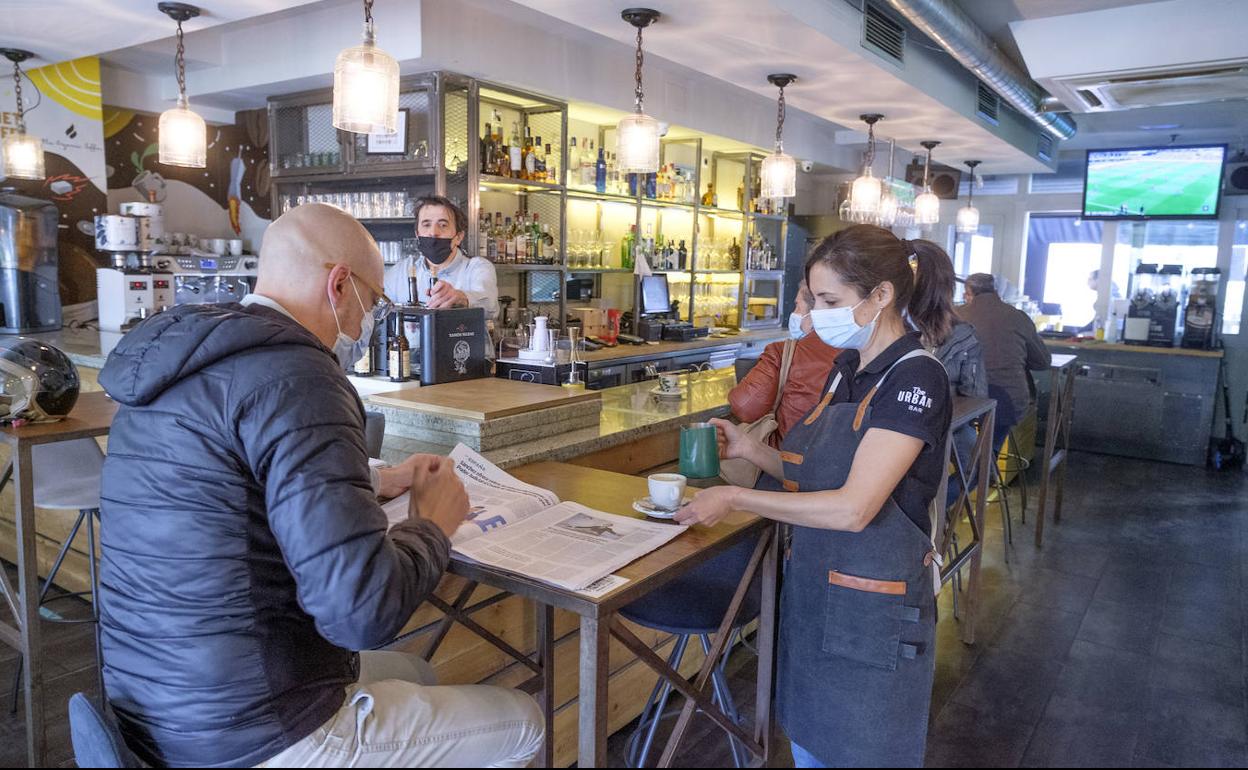 Mayte, camarera del bar Urban, atiende a un cliente con la mesa pegada a la barra.