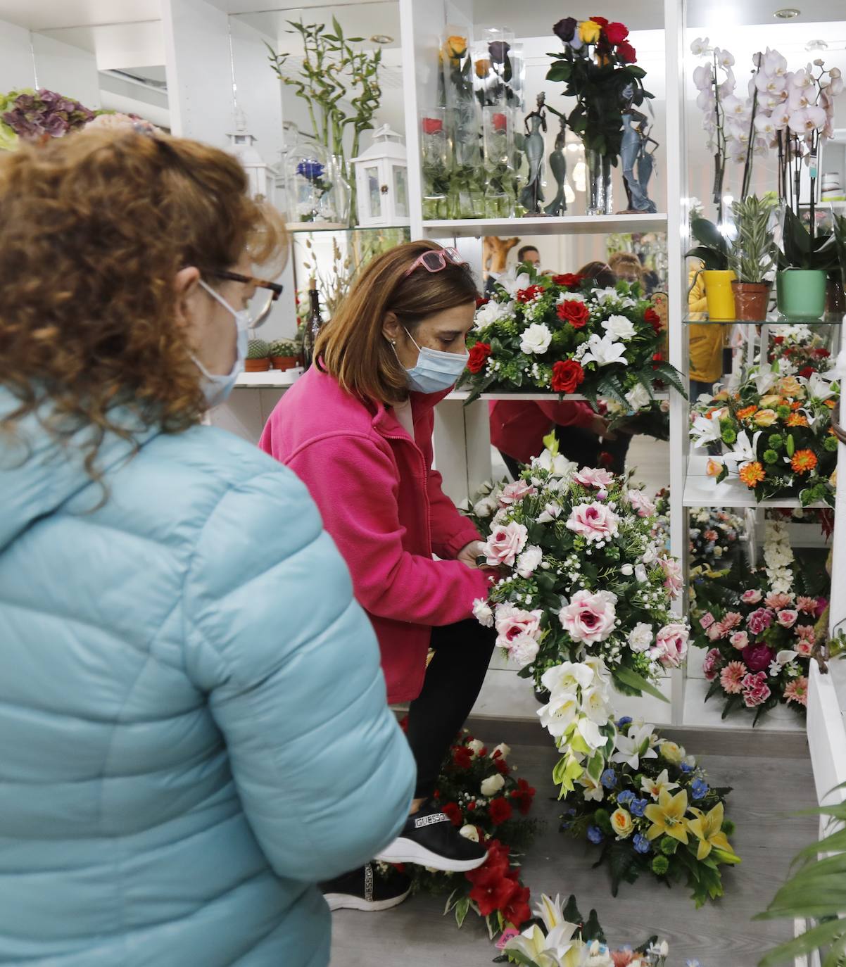 Una clienta se interesa por los centros de la floristería Pétalos.