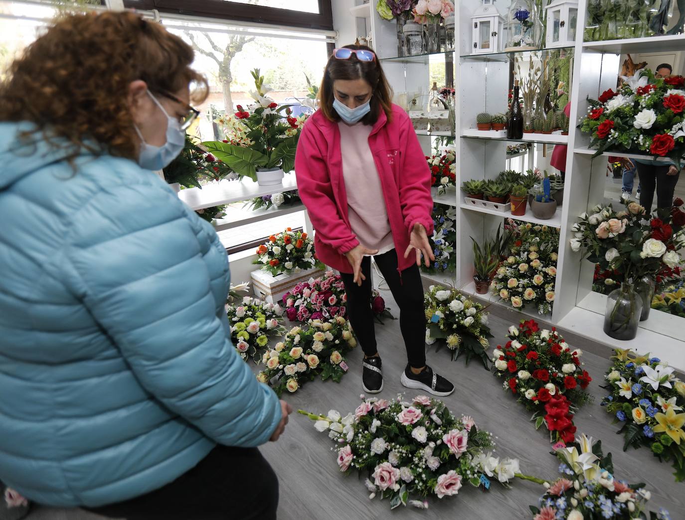 Una clienta se interesa por los centros de la floristería Pétalos.